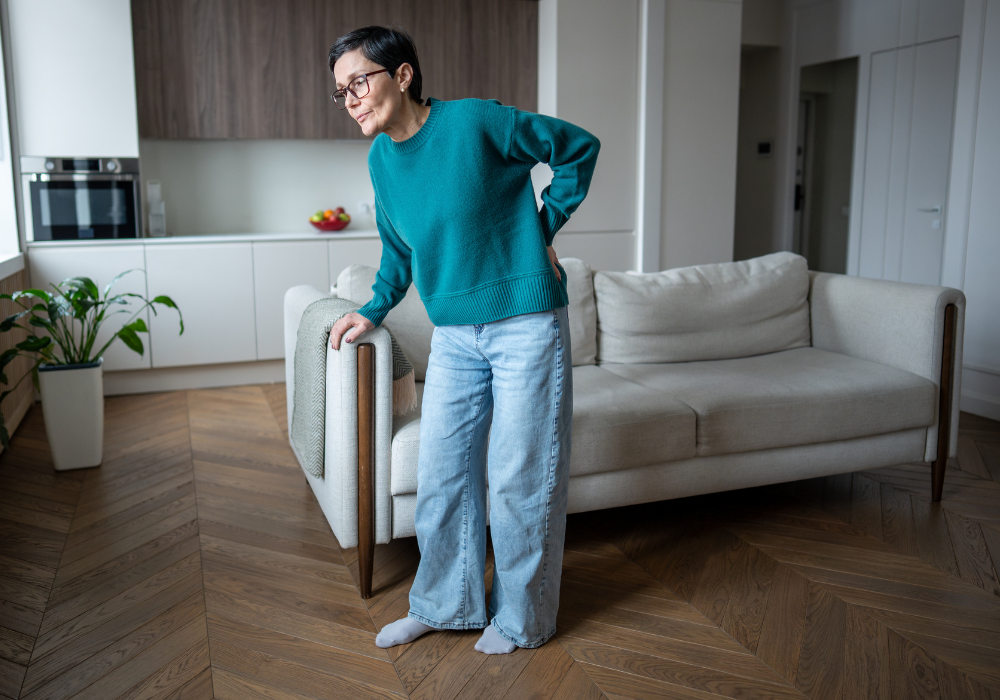 Woman experiencing back pain at home