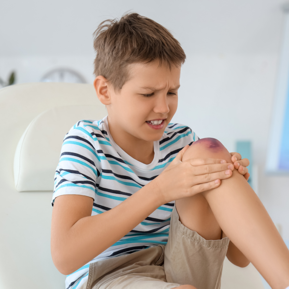 Young patient having a bruised knee injury assessed after a fall